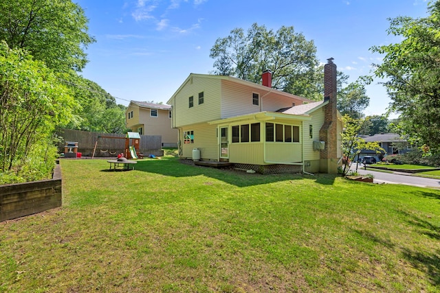 29 Ravenwood Dr, Kings Park, NY 11754 - rear view of house with a chimney, a yard, a playground, and a sunroom