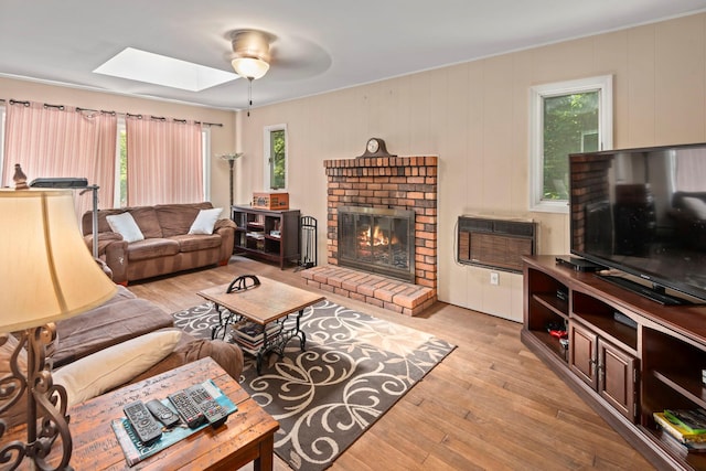 29 Ravenwood Dr, Kings Park, NY 11754 - living room with a skylight, light wood finished floors, a fireplace, a wall mounted air conditioner, and ceiling fan