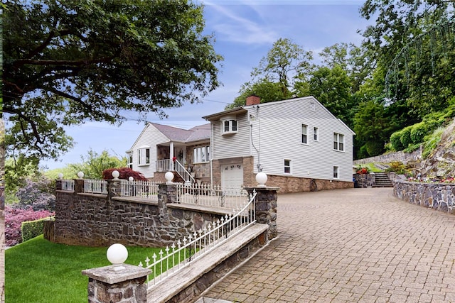 81 Avondale Rd, Yonkers, NY 10710 - rear view of property featuring a garage, stairs, a chimney, driveway, and brick siding