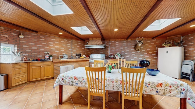 81 Avondale Rd, Yonkers, NY 10710 - kitchen featuring freestanding refrigerator, a skylight, brick wall, light tile patterned floors, and a wood ceiling with exposed beams