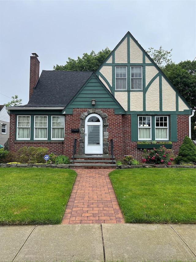 8 Alexine Ave, East Rockaway, NY 11518 - tudor-style house with brick siding, a chimney, and a front lawn