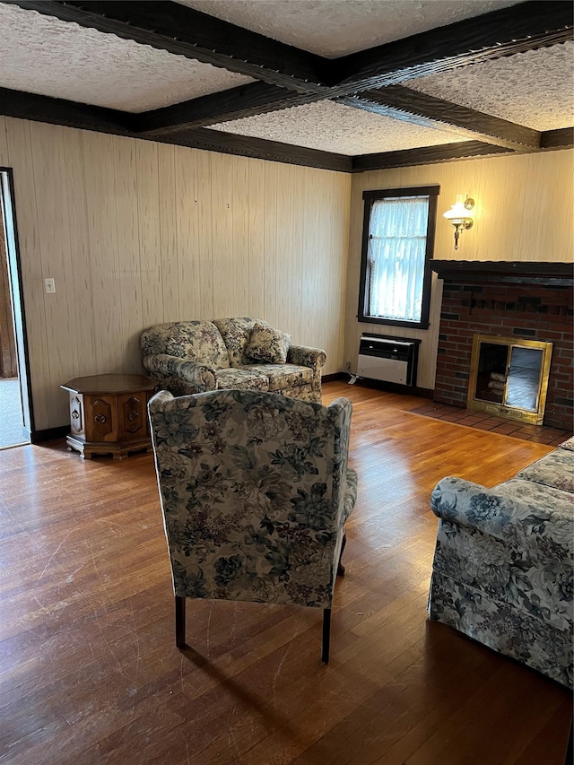 8 Alexine Ave, East Rockaway, NY 11518 - living area featuring beamed ceiling, wooden walls, hardwood / wood-style floors, a fireplace, and a textured ceiling