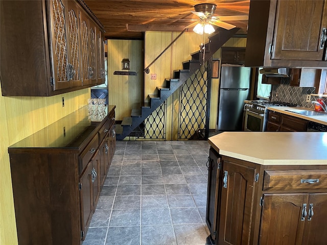 8 Alexine Ave, East Rockaway, NY 11518 - kitchen featuring freestanding refrigerator, stainless steel stove, a sink, wood walls, and dark brown cabinetry
