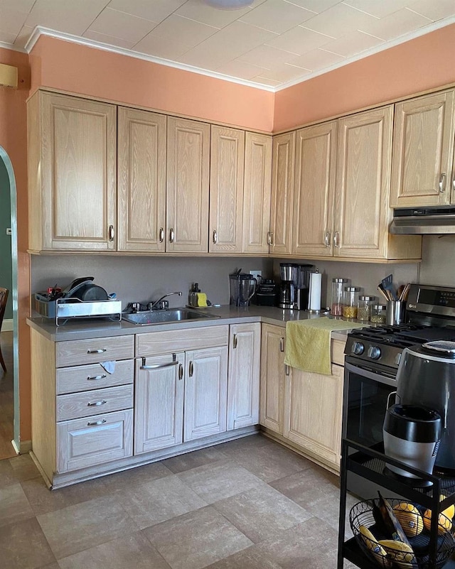 6910 68th St, Glendale, NY 11385 - kitchen with under cabinet range hood, a sink, arched walkways, stainless steel range with gas stovetop, and light brown cabinetry