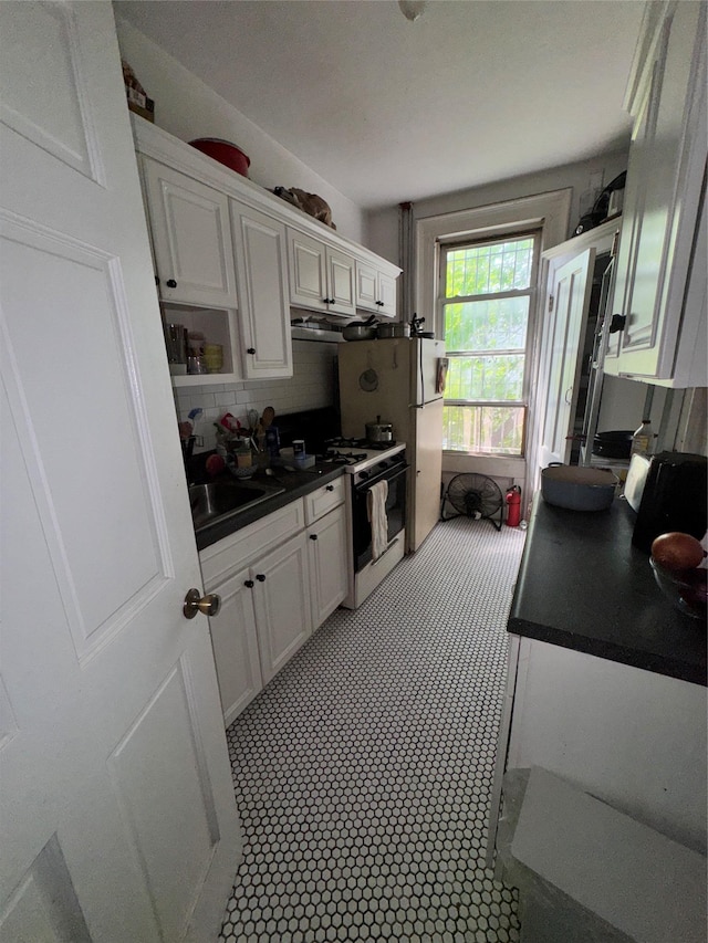21 Jefferson St, Brooklyn, NY 11206 - kitchen with range with gas stovetop, white cabinets, and dark countertops