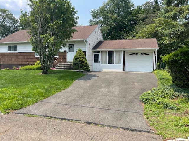 23 Elm St, Garnerville, NY 10923 - tri-level home with an attached garage, asphalt driveway, and a front lawn