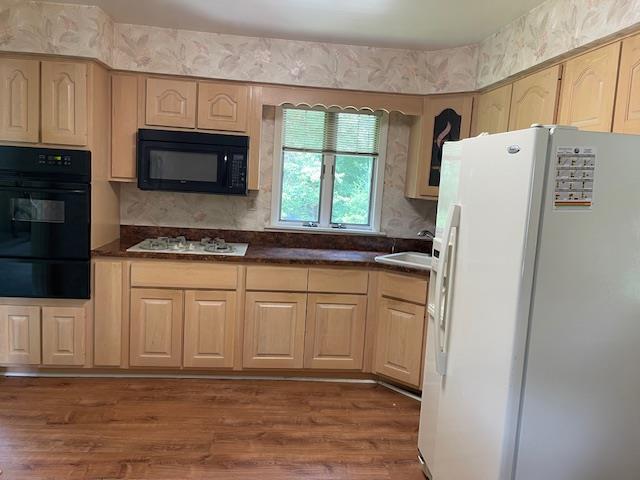 23 Elm St, Garnerville, NY 10923 - kitchen with black appliances, a warming drawer, dark countertops, dark wood-style flooring, and light brown cabinetry