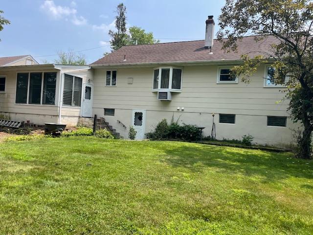 23 Elm St, Garnerville, NY 10923 - back of property with a chimney, a lawn, and a sunroom