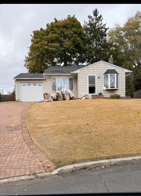 7 Byrd Ct, Kings Park, NY 11754 - view of front facade with an attached garage, a chimney, decorative driveway, and a front lawn