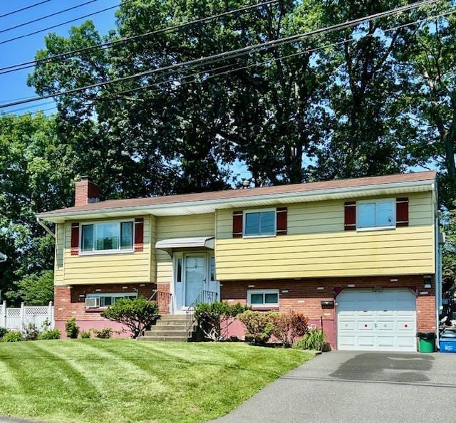 25 Waldron Dr, Stony Point, NY 10980 - split foyer home with brick siding, a garage, a chimney, and driveway