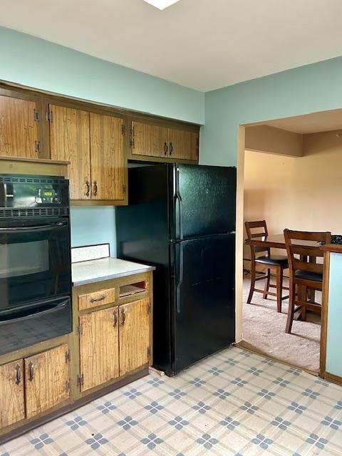 25 Waldron Dr, Stony Point, NY 10980 - kitchen with black appliances, a warming drawer, light countertops, light floors, and brown cabinetry
