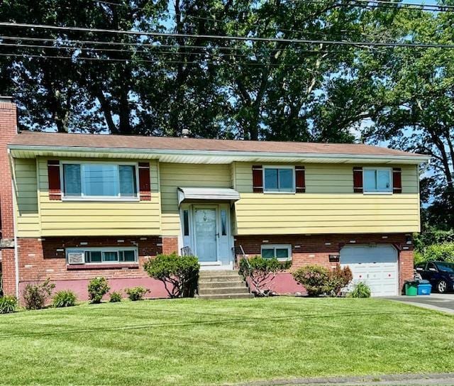 25 Waldron Dr, Stony Point, NY 10980 - split foyer home with brick siding, a garage, a front yard, and driveway