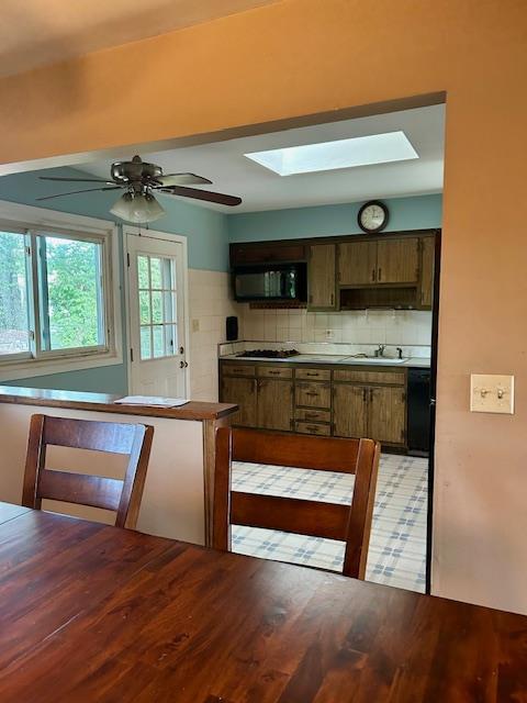 25 Waldron Dr, Stony Point, NY 10980 - kitchen featuring black microwave, a skylight, tasteful backsplash, ceiling fan, and gas cooktop