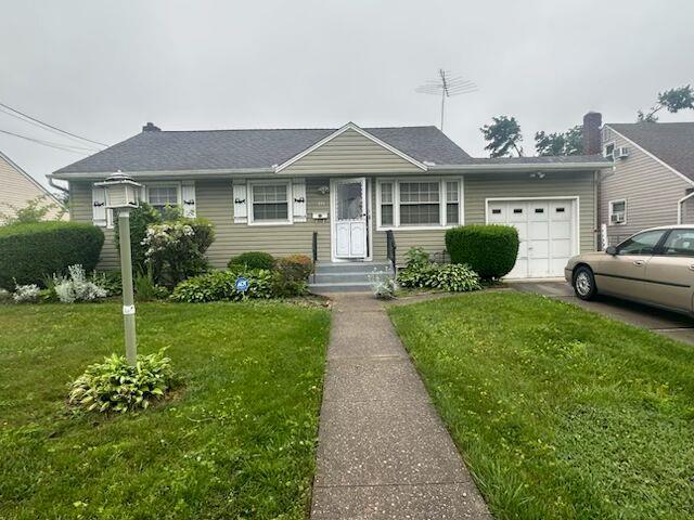 475 Emerson St, Uniondale, NY 11553 - view of front of property with an attached garage, a front lawn, and driveway