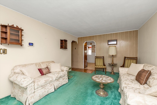 475 Emerson St, Uniondale, NY 11553 - living room with arched walkways, carpet flooring, crown molding, and wood walls