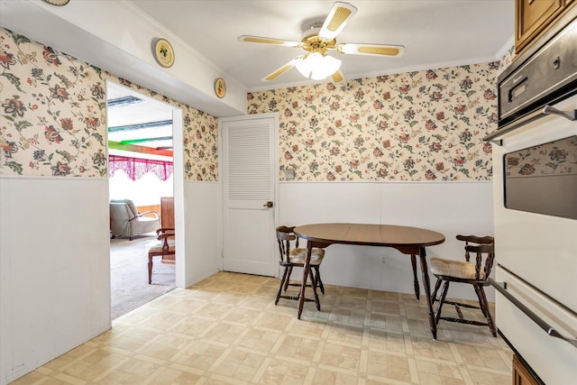 475 Emerson St, Uniondale, NY 11553 - dining space featuring wainscoting, light flooring, wallpapered walls, crown molding, and ceiling fan