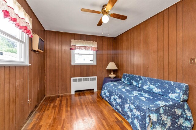 475 Emerson St, Uniondale, NY 11553 - bedroom with radiator, a wall mounted AC, hardwood / wood-style flooring, and wooden walls
