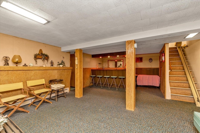 475 Emerson St, Uniondale, NY 11553 - finished below grade area with carpet, stairs, a bar, baseboard heating, and wood walls