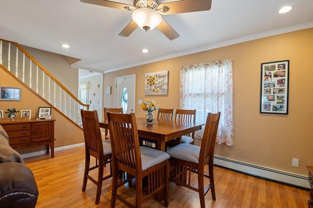 37 Swan Ln, Levittown, NY 11756 - dining room featuring baseboard heating, light wood-style flooring, stairway, a ceiling fan, and ornamental molding