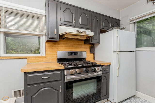 52 Newkirk Rd, Yonkers, NY 10710 - kitchen featuring stainless steel gas range, under cabinet range hood, freestanding refrigerator, decorative backsplash, and gray cabinetry