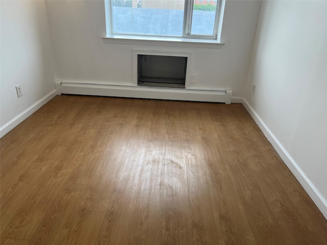55-05 98th St, Corona, NY 11368 - unfurnished living room featuring baseboard heating and wood finished floors