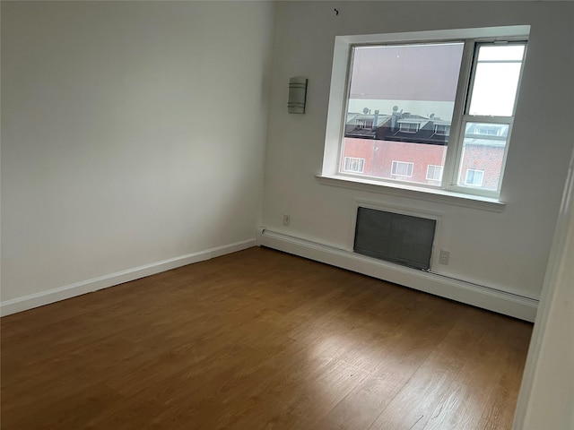 55-05 98th St, Corona, NY 11368 - spare room featuring baseboard heating and wood finished floors