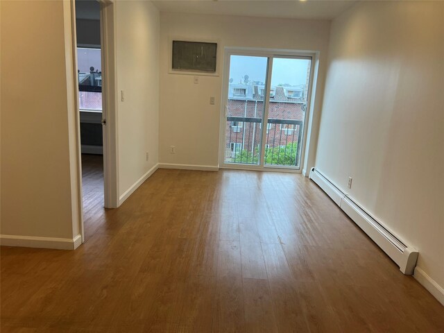 55-05 98th St, Corona, NY 11368 - spare room featuring a baseboard radiator and wood finished floors