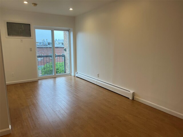 55-05 98th St, Corona, NY 11368 - empty room with a baseboard radiator, wood finished floors, recessed lighting, and a smoke detector