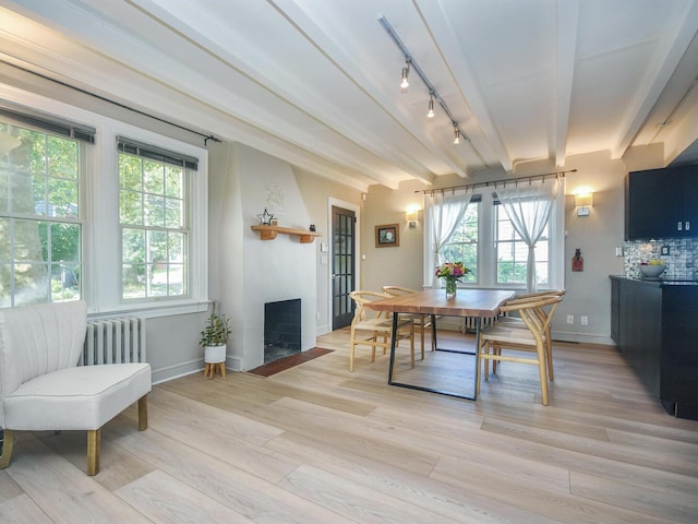 20 Oldwood Rd, Port Washington, NY 11050 - dining area with radiator, a fireplace, plenty of natural light, light wood-style floors, and beam ceiling