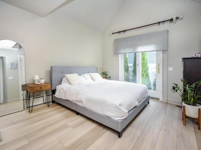 20 Oldwood Rd, Port Washington, NY 11050 - bedroom with high vaulted ceiling, arched walkways, light wood-style floors, and access to exterior