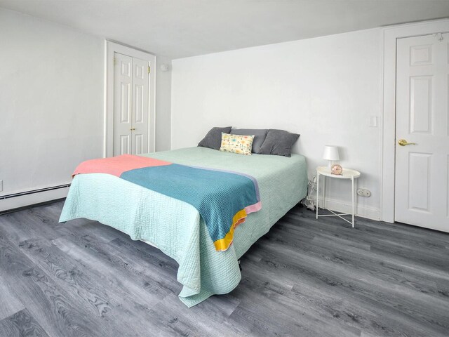 20 Oldwood Rd, Port Washington, NY 11050 - bedroom with wood finished floors, a baseboard radiator, and a closet