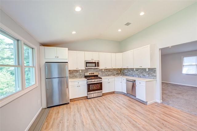 1350 Islip Ave, Brentwood, NY 11717 - kitchen with stainless steel appliances, light countertops, lofted ceiling, tasteful backsplash, and white cabinetry