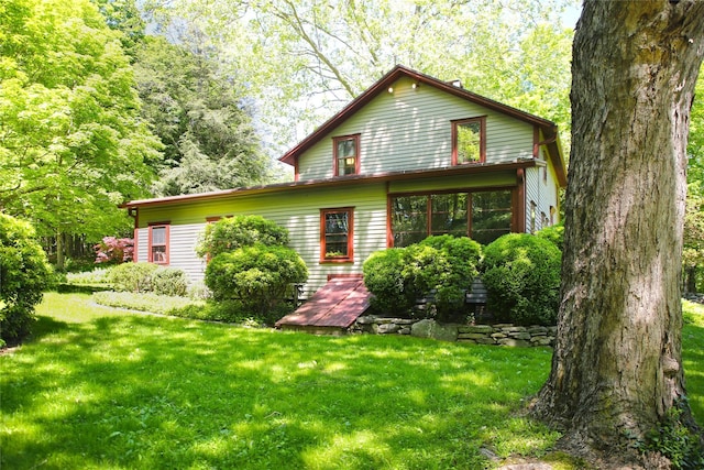 rear view of house featuring a yard