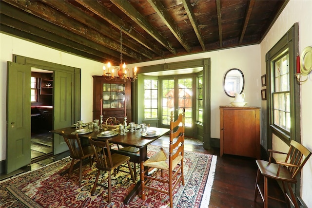 dining space featuring french doors, a chandelier, and dark wood finished floors