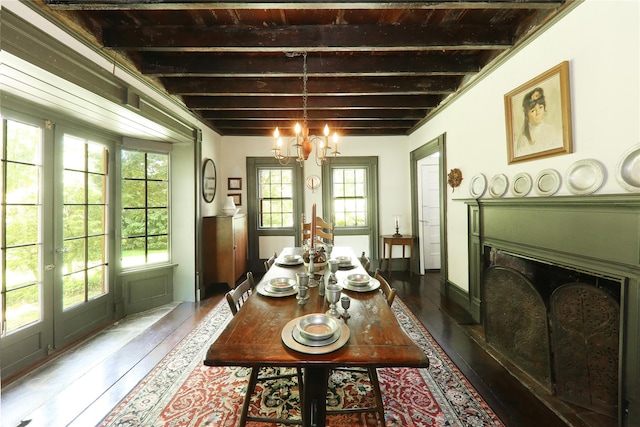dining space with plenty of natural light, a chandelier, dark wood-style floors, and a fireplace