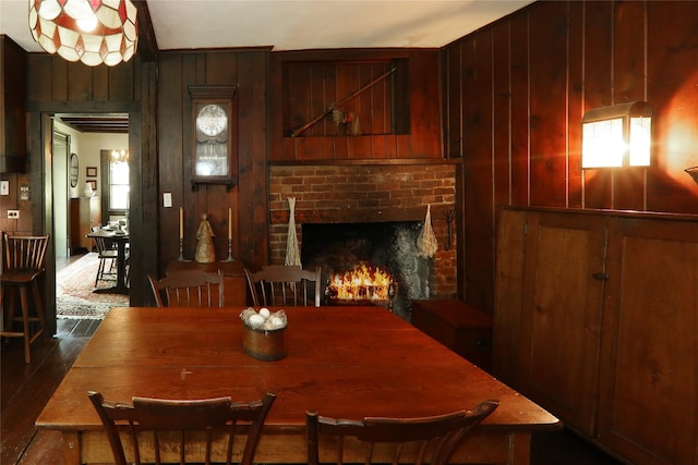 dining area featuring wooden walls and a fireplace