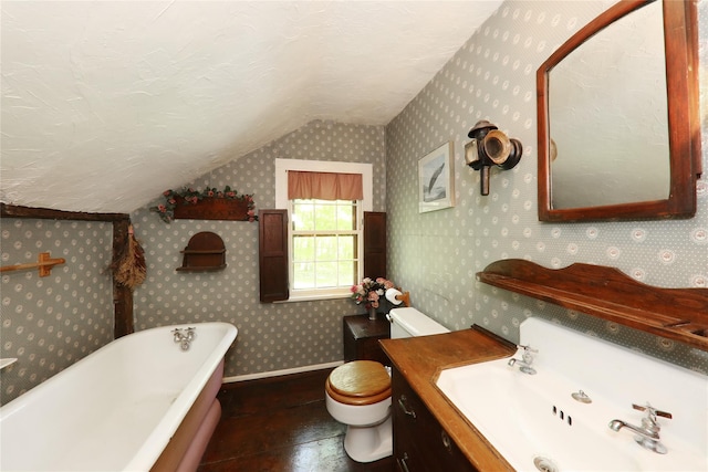 full bath featuring lofted ceiling, wallpapered walls, a soaking tub, and vanity