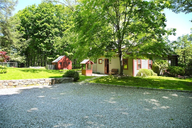 view of front of property featuring a front lawn and a storage unit