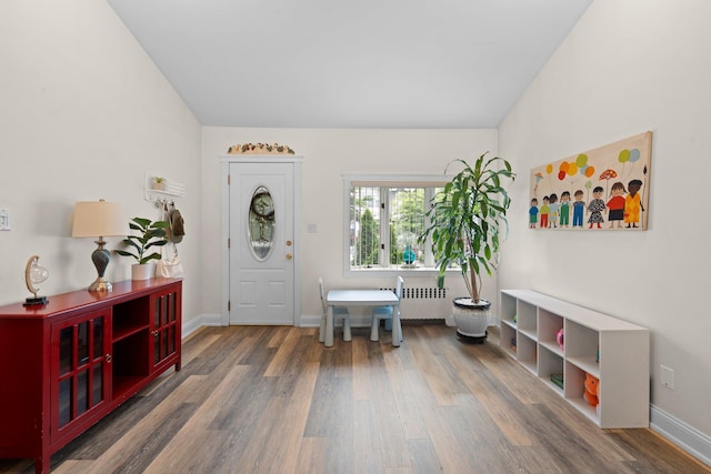 78-32 76th St, Glendale, NY 11385 - foyer entrance with wood finished floors, radiator heating unit, and baseboards