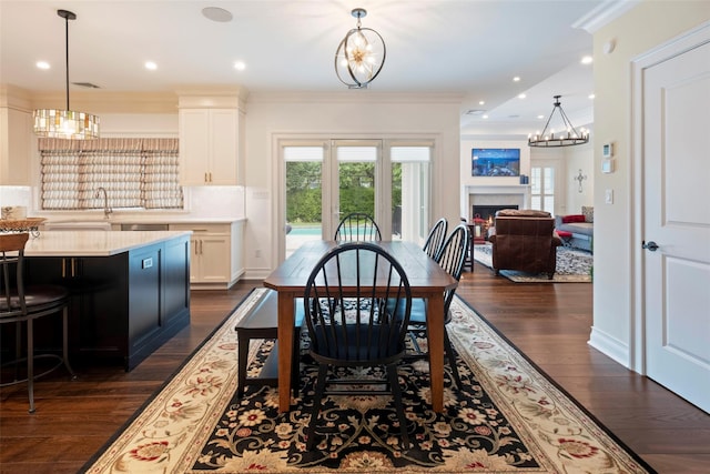 77 Crabapple Rd, Manhasset, NY 11030 - dining area featuring dark wood finished floors, a warm lit fireplace, crown molding, a chandelier, and recessed lighting
