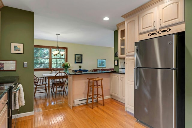 38 Sunset Dr, Brewster, NY 10509 - kitchen featuring appliances with stainless steel finishes, a peninsula, light wood-style flooring, dark countertops, and recessed lighting