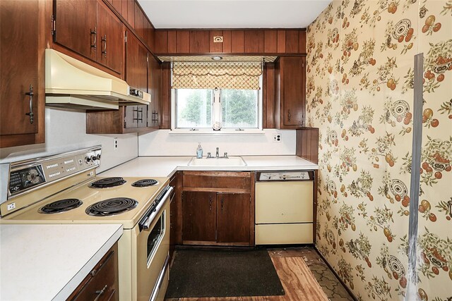 6 Pequot Ave, Port Washington, NY 11050 - kitchen with white appliances, under cabinet range hood, a sink, light countertops, and wallpapered walls