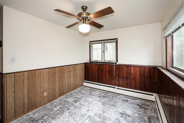 6 Pequot Ave, Port Washington, NY 11050 - unfurnished room with a wainscoted wall, wood walls, ceiling fan, and baseboard heating