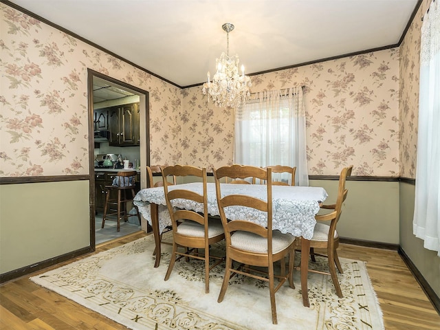 2195 3rd St, East Meadow, NY 11554 - dining space with light wood-type flooring, a chandelier, crown molding, a wainscoted wall, and wallpapered walls
