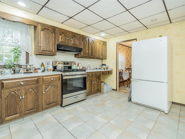 2195 3rd St, East Meadow, NY 11554 - kitchen featuring freestanding refrigerator, stainless steel range with gas stovetop, under cabinet range hood, light countertops, and a drop ceiling