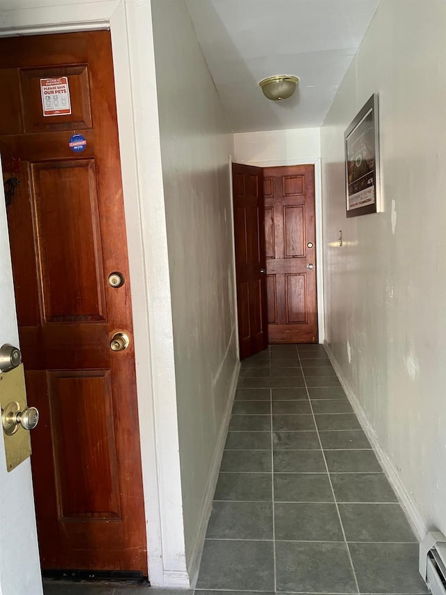 724A E 223rd St, Bronx, NY 10466 - hall with a baseboard heating unit, dark tile patterned floors, and baseboards