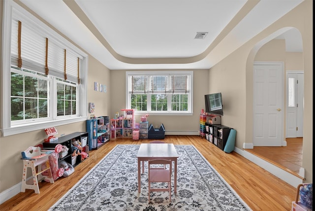 2 SE Ct, Wallkill, NY 12589 - playroom featuring arched walkways, wood finished floors, baseboard heating, and a tray ceiling