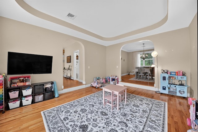 2 SE Ct, Wallkill, NY 12589 - living area with arched walkways, a chandelier, a tray ceiling, and wood finished floors