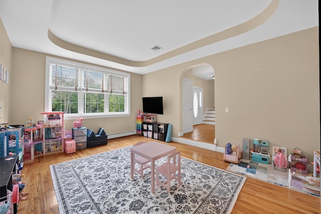 2 SE Ct, Wallkill, NY 12589 - living room featuring a baseboard radiator, arched walkways, wood finished floors, and a raised ceiling