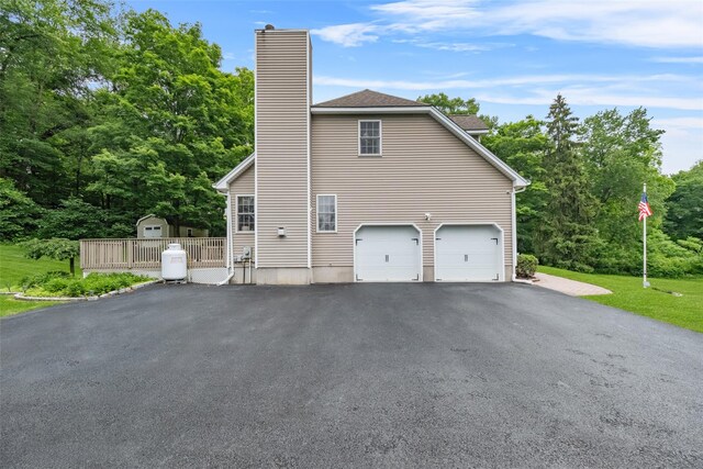 2 SE Ct, Wallkill, NY 12589 - view of home's exterior featuring driveway, a chimney, an attached garage, and a storage shed